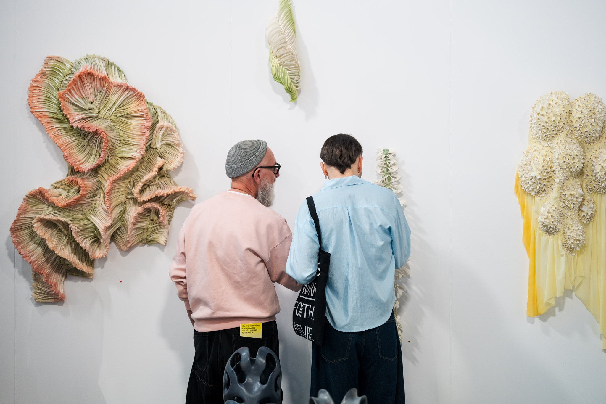 Visitors looking at ceramic wall works